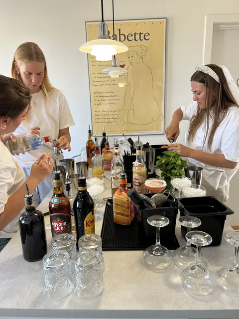 Kursusdeltagere mixer cocktails sammen ved barbordet