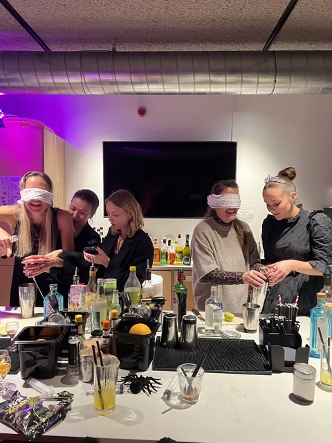 Hold hjælper hinanden med at mixe cocktails med bind for øjnene